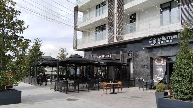 A modern building with a Starbucks and a restaurant named ekme gurme. - Cozy Retreat: Stylish 1BR Apt (Esenyurt)
