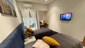 Une chambre d’hôtel moderne équipée d’un grand lit, d’un canapé, d’un bureau et d’une télévision.