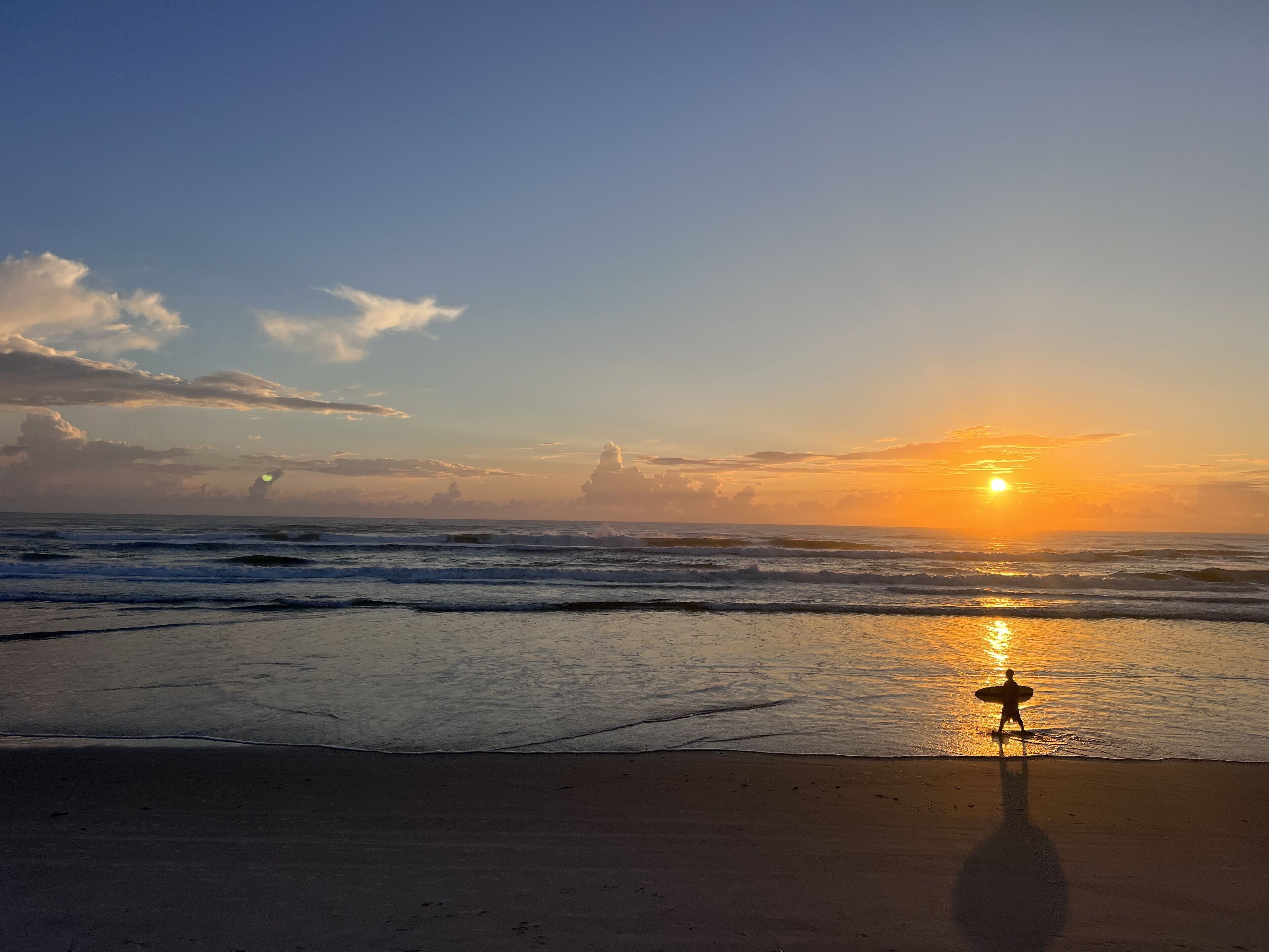A beach scene with waves and a sunset.