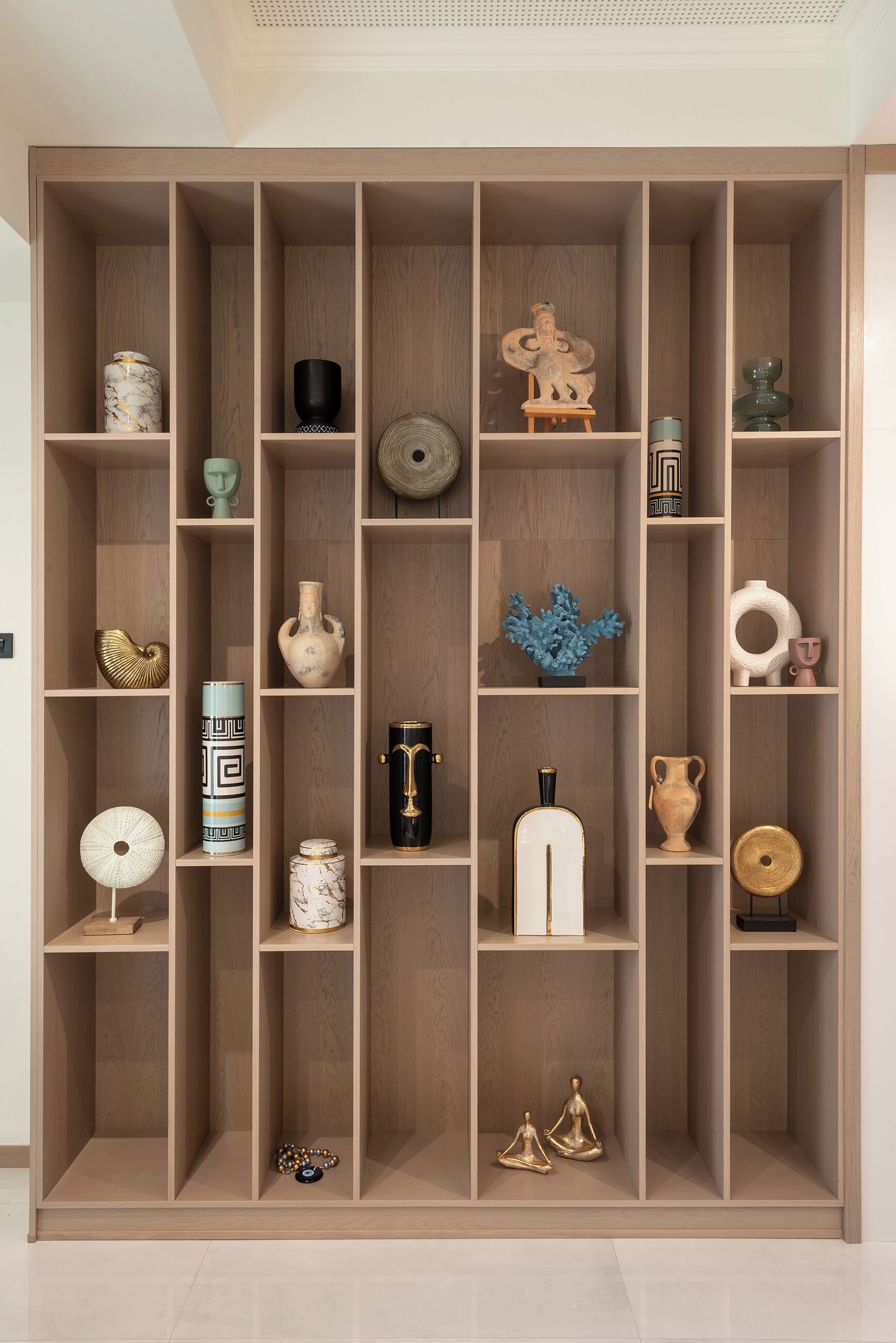 Una estantería de madera con diversos objetos decorativos.