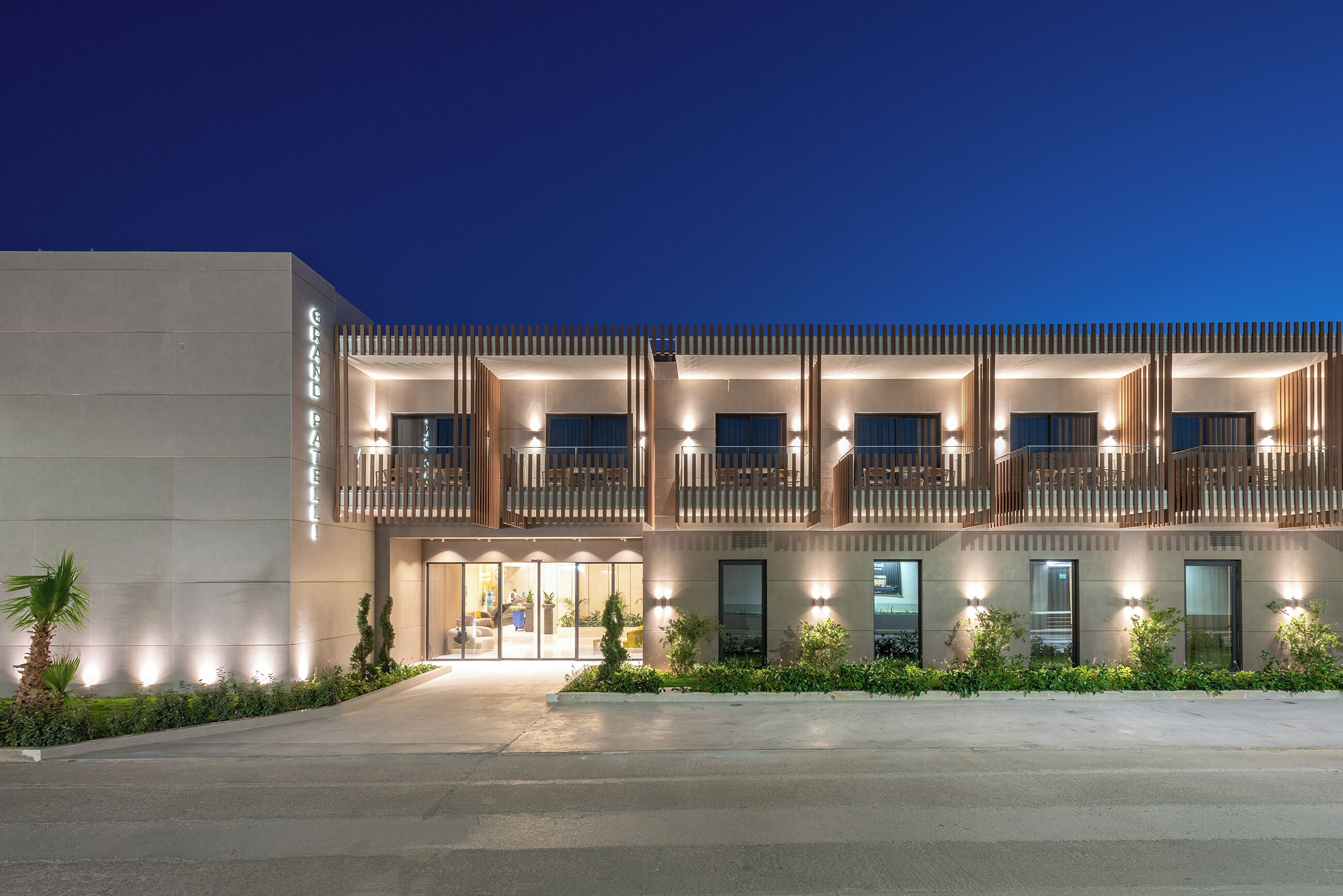 A modern hotel with a flat facade, large windows, and a well-lit entrance.