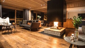 Ein modernes Wohnzimmer mit Kamin, Holzboden und einer gemütlichen Sitzecke.