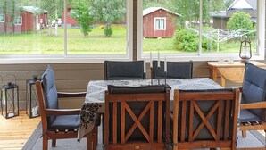 A dining area with a table and chairs, a view of a red barn and greenery outside. - 3 bedroom awesome home in Malungsfors (Malungsfors)