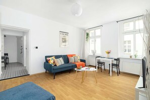 Un salon moderne avec un canapé, une table basse et un coin repas.