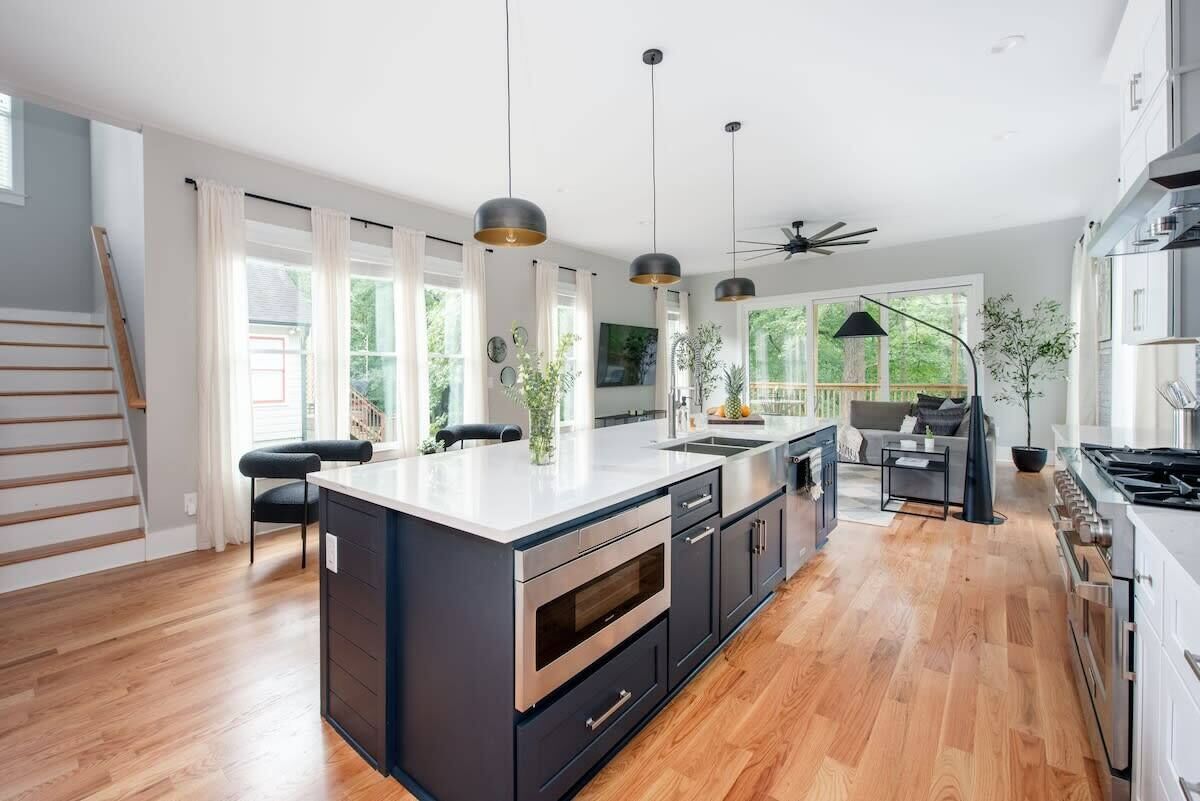 A modern kitchen with a central island, stainless steel appliances, and pendant lighting.