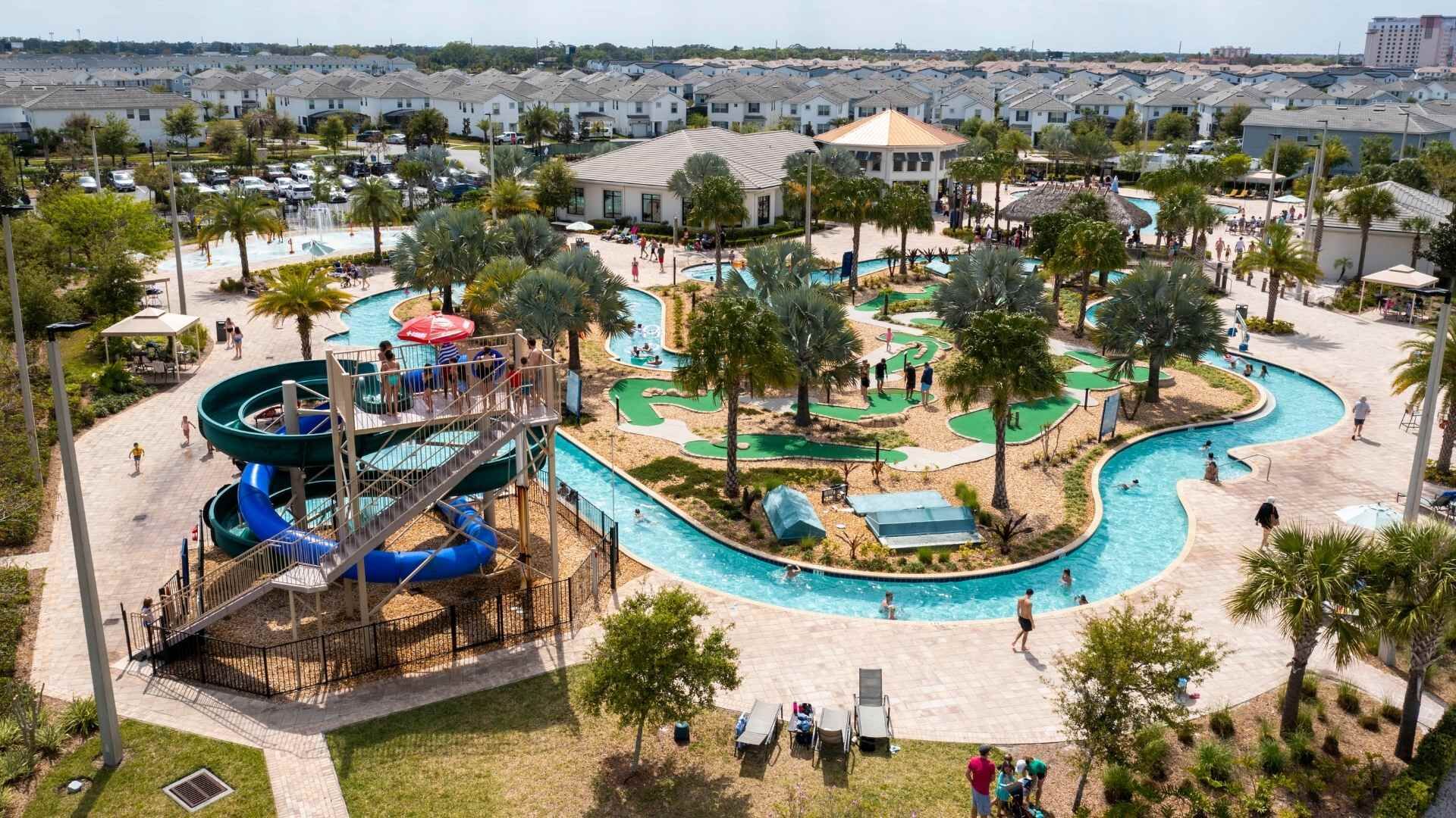 Een waterpark met verschillende zwembaden, glijbanen en een golfbaan.