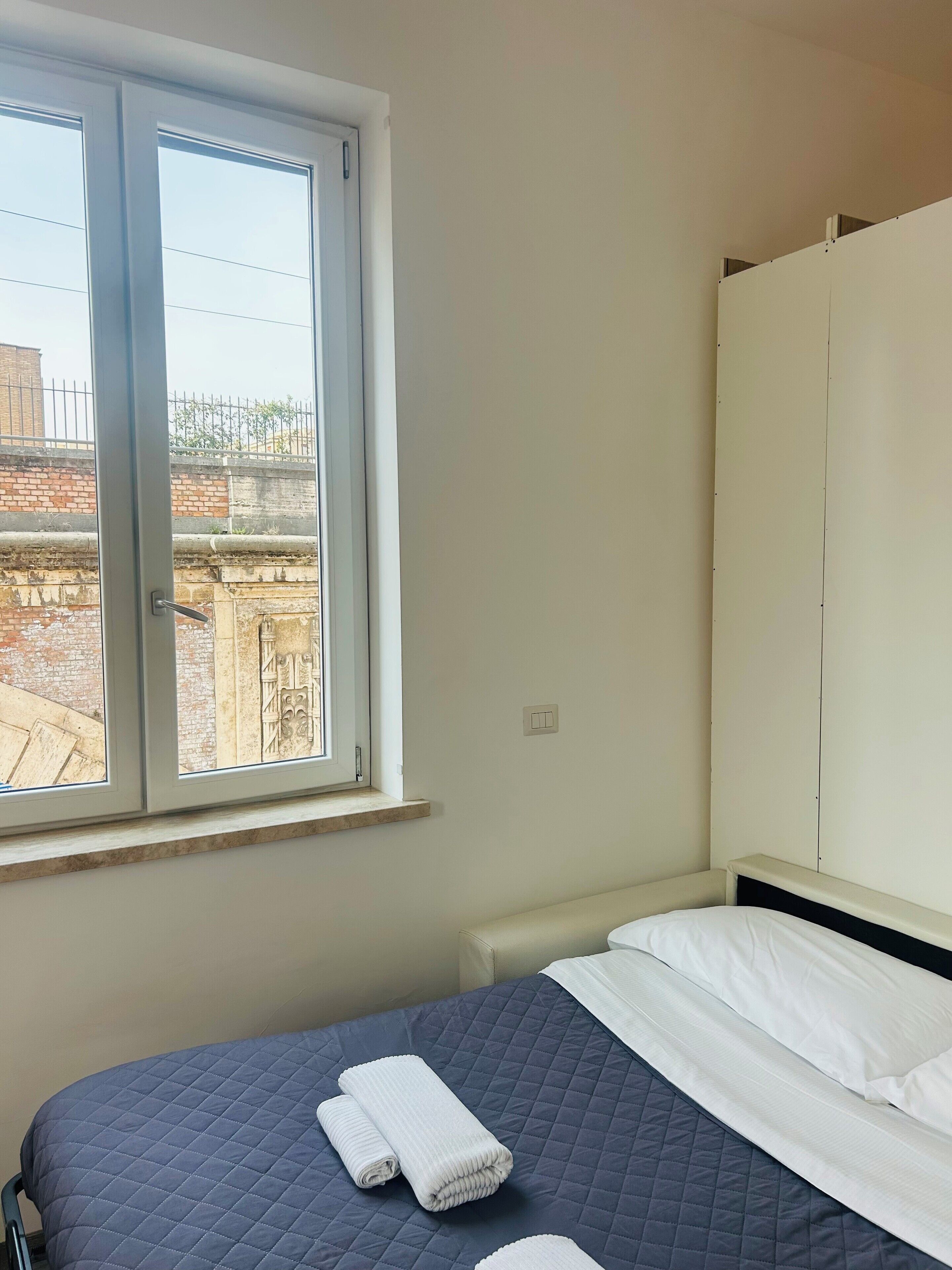 Une chambre à coucher avec un lit, une fenêtre et une armoire.