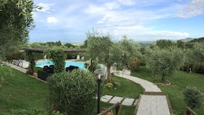 A garden with a swimming pool, outdoor seating, and a stone pathway. - Villa Le Ripe - Gambassi Terme, Toscana (Gambassi Terme)