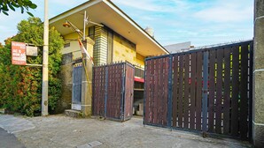 A gated residential area with a house featuring a tiled facade and a water tank on the roof. - OYO Life 92641 Guest House Palinggihan Ii (Sumber)