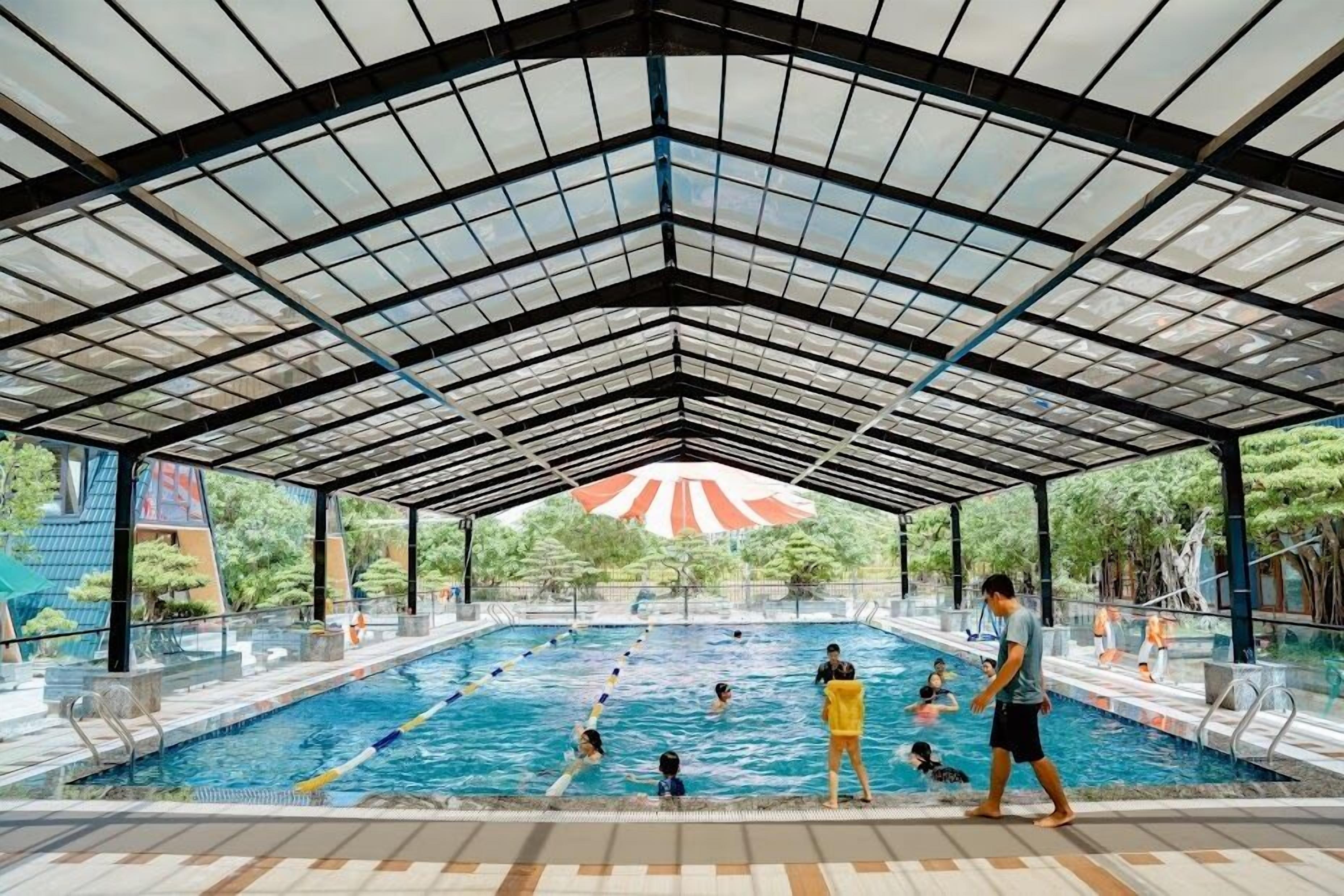 Una piscina interna con soffitto in vetro e area coperta.