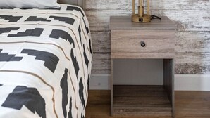 A bedroom with a bed, a nightstand, and a lamp.