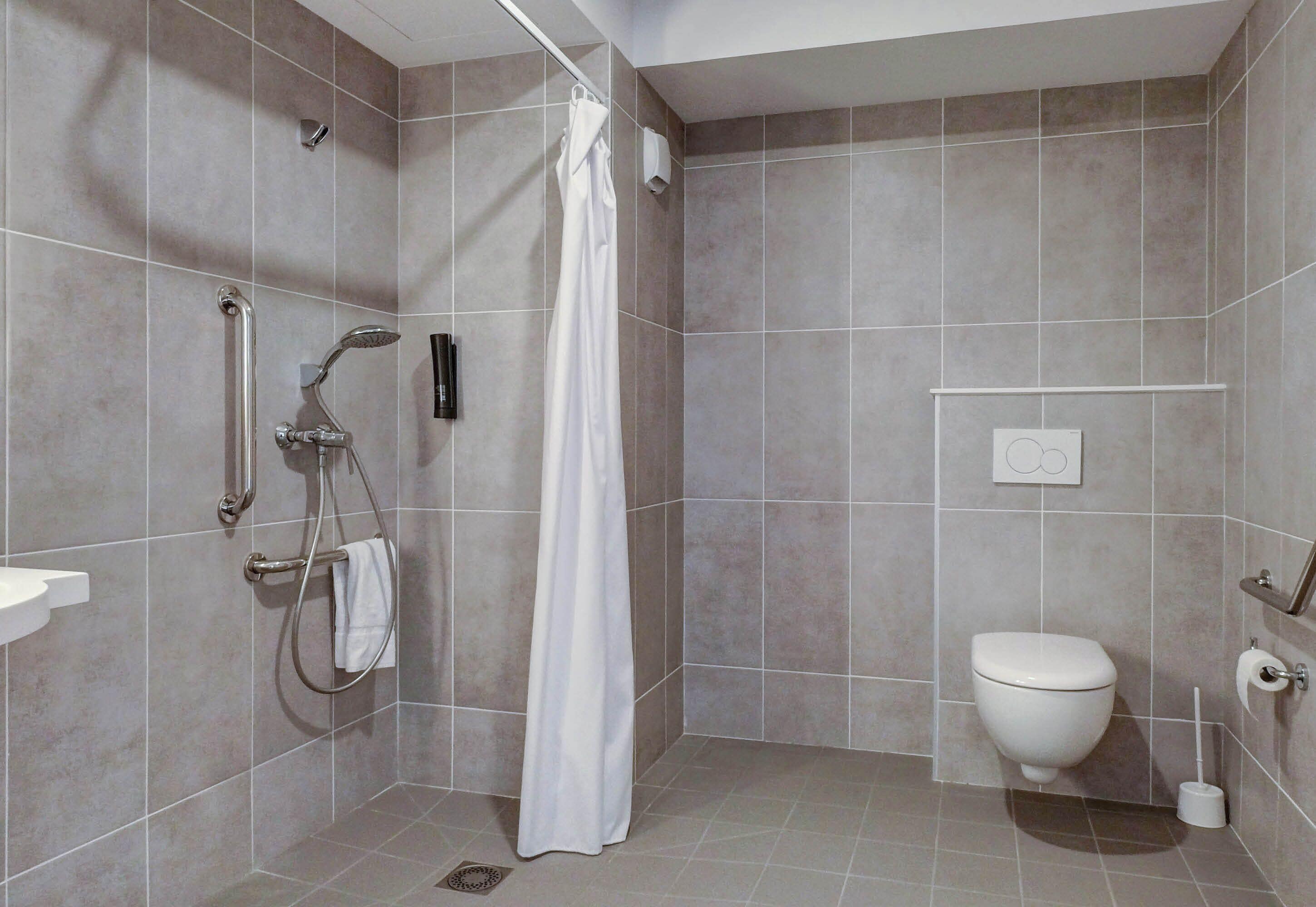Un baño moderno con ducha, inodoro y lavamanos.