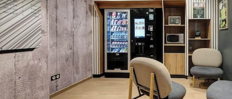 A modern interior with a vending machine, seating area, and a wall with a large number '0'.