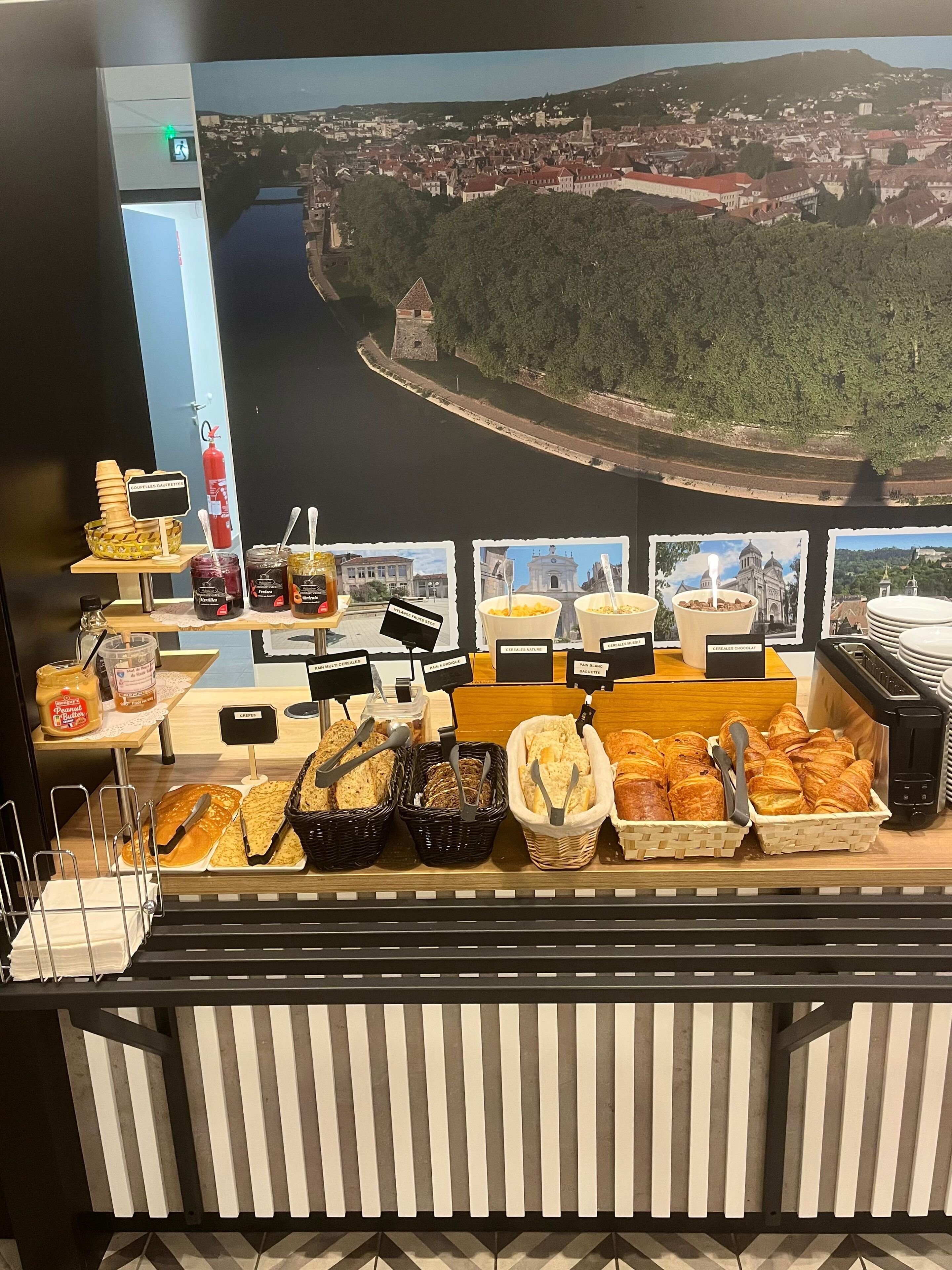 A buffet setup with various food items and a view of a cityscape in the background.