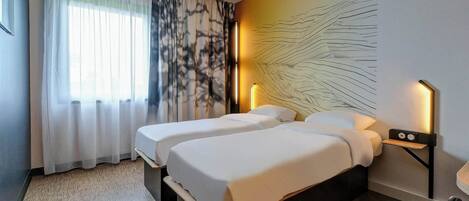 A hotel room with two beds, a large window with sheer curtains, a wall art piece, and bedside lamps.
