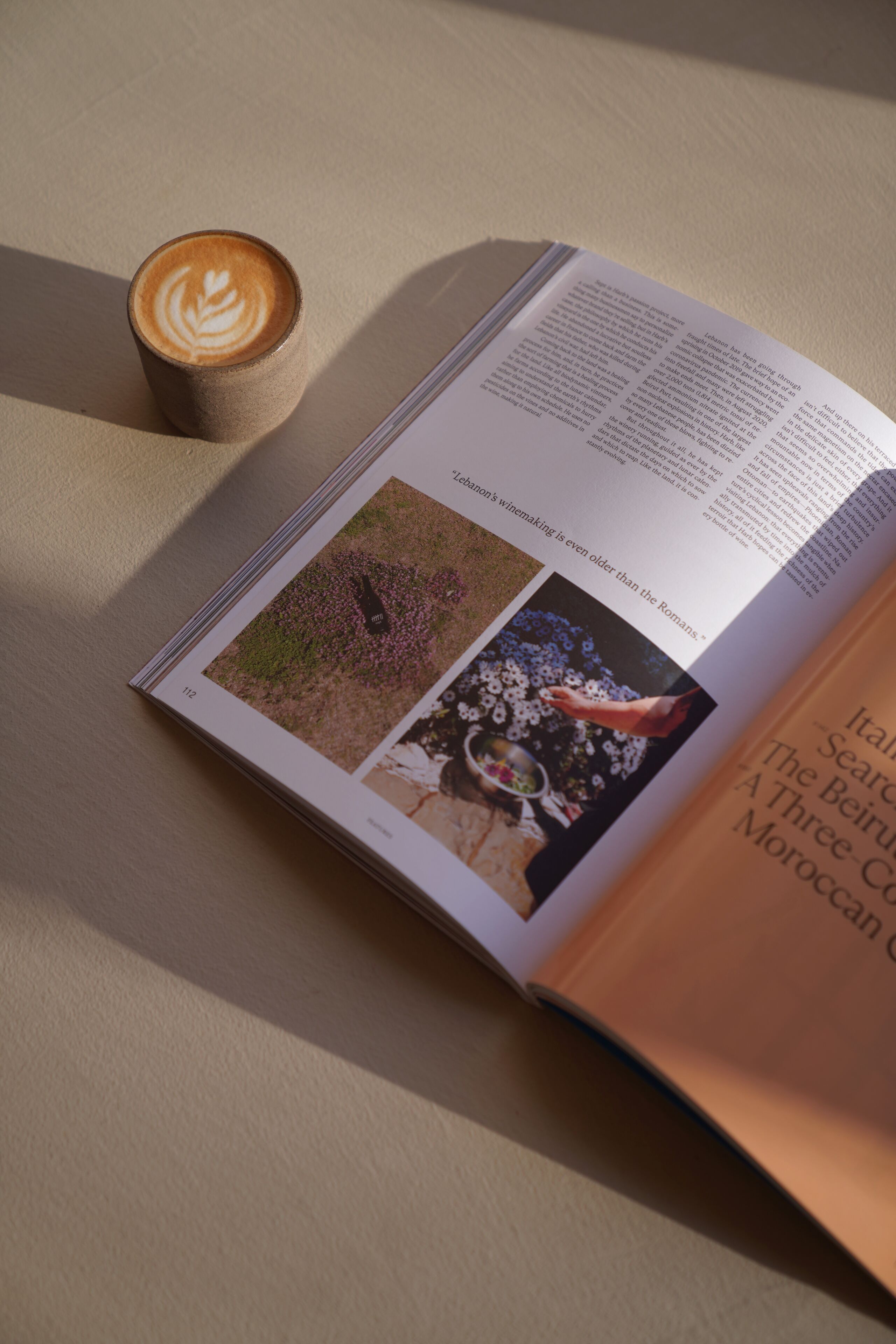 An open book with a coffee cup beside it.