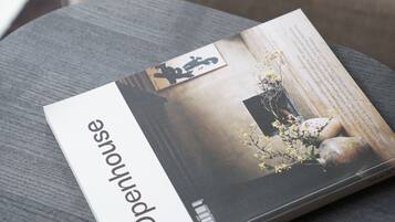 A magazine on a round table with a cushion in the background.