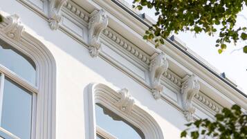Ein Gebäude mit drei Rundbogenfenstern und aufwendigen architektonischen Verzierungen.