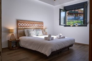 A bedroom with a bed, bedside lamps, a window with a view, and a patterned headboard. - Basque Haven by Fidalsa (Zeanuri)