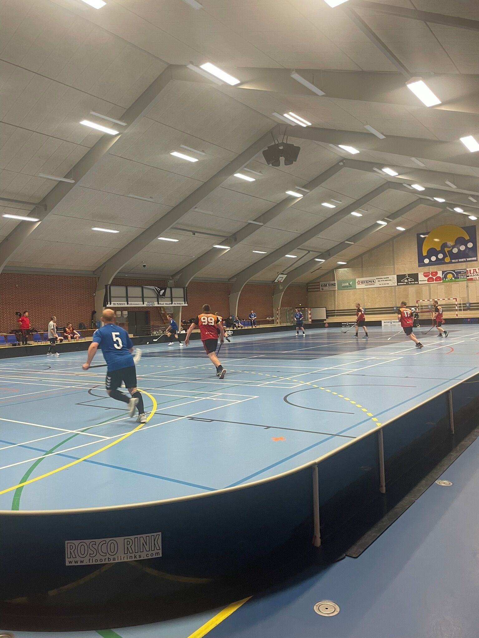 En inomhushall där man kan utöva olika sporter, bland annat med en basketkorg och ett volleybollnät.