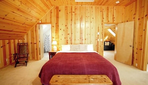 Una stanza con rivestimenti in legno, un letto, una sedia e una lampada.