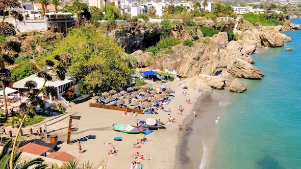 A coastal beach with rocky cliffs, a clear blue sea, and a mountainous backdrop. - Apartamento con vistas al mar lateral (Torrox Costa)