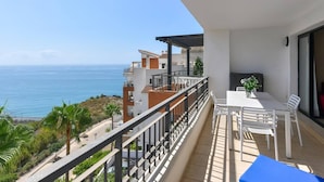A balcony with a table and chairs, overlooking the sea. - Apartamento con vistas al mar lateral (Torrox Costa)