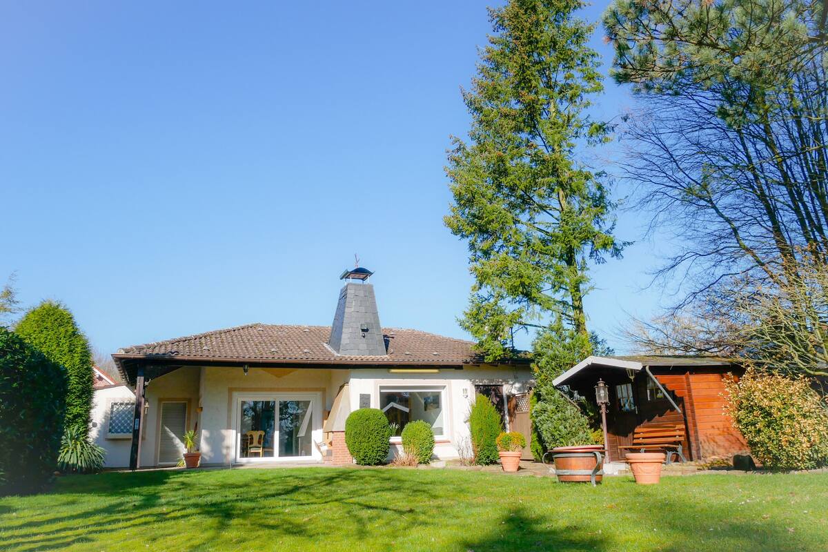 A house with a tiled roof, a chimney, and a front porch.