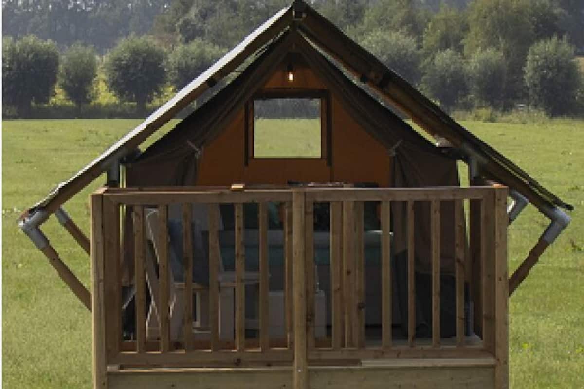 A wooden cabin with a balcony and a staircase leading to a lower level.