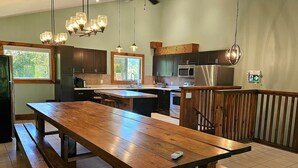 Una cocina moderna con detalles de madera, electrodomésticos de acero inoxidable e iluminación colgante.