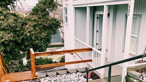Un immeuble résidentiel doté d’un porche, d’un escalier et d’une balustrade en bois.