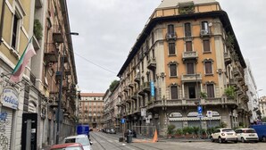 A street view with a hotel named "HOTEL" on a corner building. - Hotel Calypso (Milan)