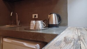 A kitchen with a stainless steel kettle, a coffee maker, and a sink. - Hotel Calypso (Milan)