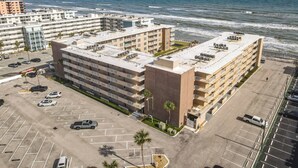 A beachfront hotel with multiple floors, parking, and ocean views.