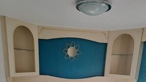 Une chambre à coucher avec un lit, un luminaire décoratif au plafond et des étagères intégrées.