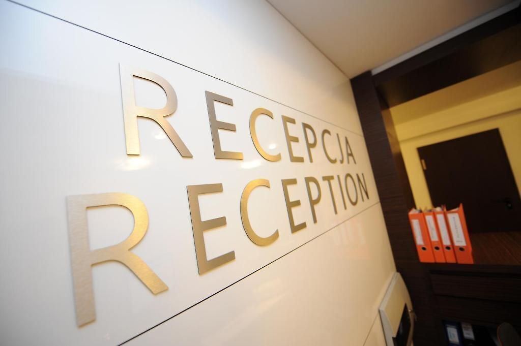 Ein Empfangsbereich mit einem Schild, auf dem 'RECEPCIA RECEPTION' steht.