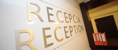 Un área de recepción con un cartel que dice 'RECEPCIA RECEPTION'.