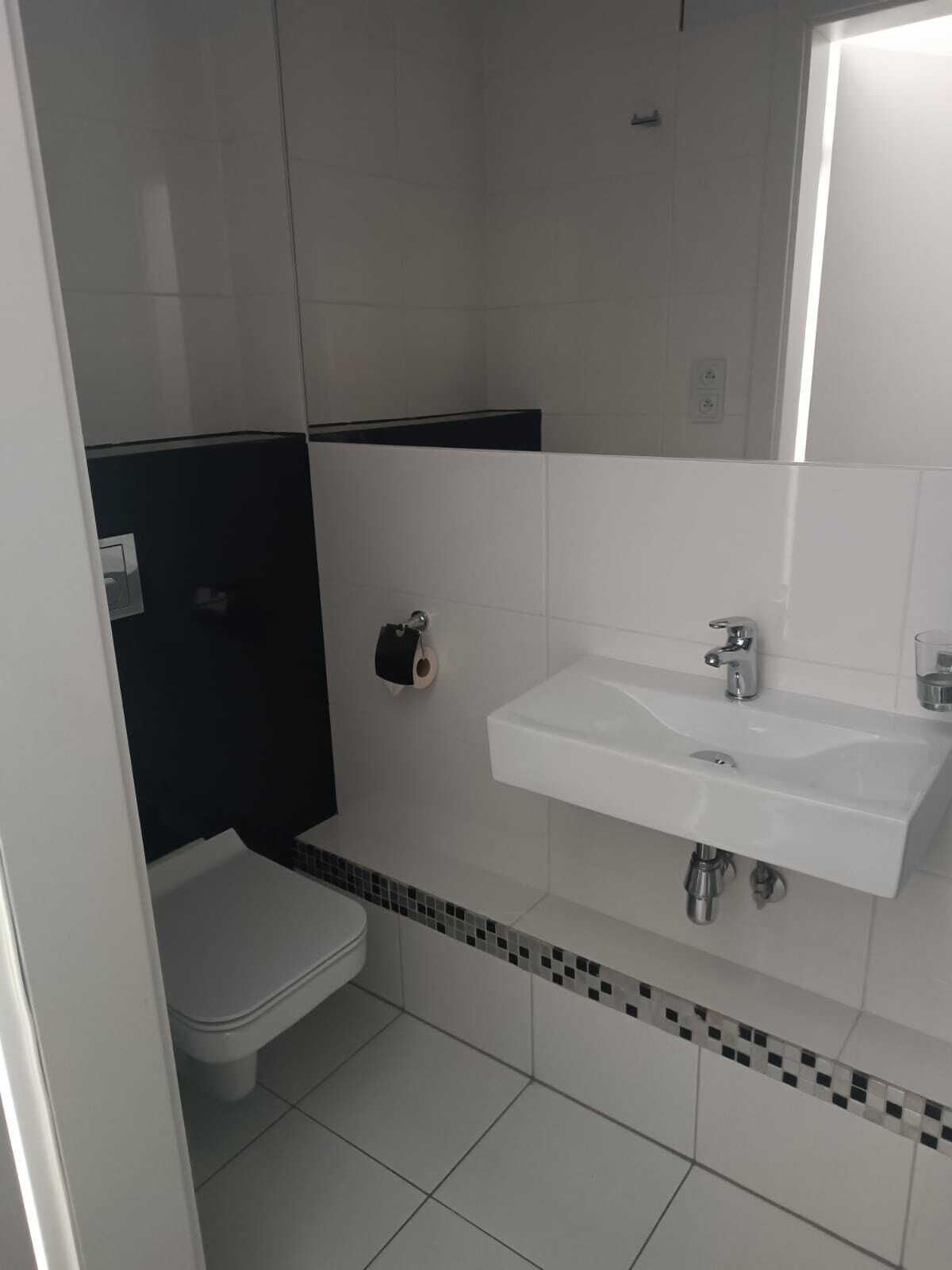 Une salle de bain avec des toilettes, un lavabo et un miroir.