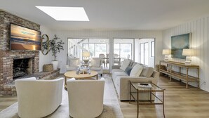 Un salon spacieux doté d’une cheminée, de sièges confortables et de grandes fenêtres.