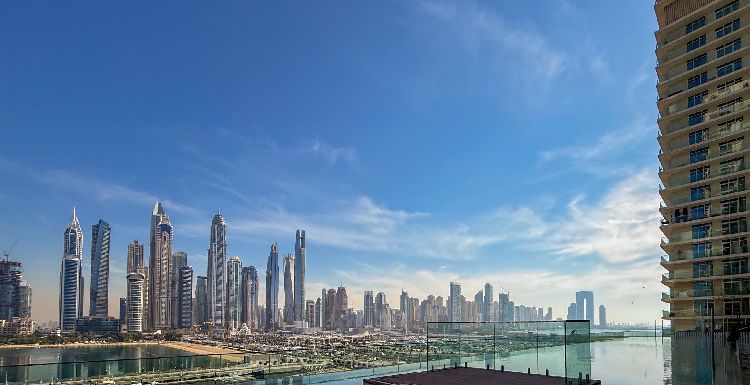 A high-rise building with a view of a city skyline and a body of water.