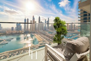 Un lujoso hotel de gran altura en Dubái con vistas al horizonte de la ciudad, al puerto deportivo y a cuerpos de agua.