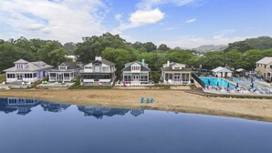 A beachfront property with multiple houses, a swimming pool, and a reflection pool.