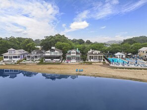 Ein Strandgrundstück mit mehreren Häusern, einem Schwimmbad und einem Reflexionsbecken.