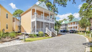 A two-story house with a porch and a staircase leading to the second floor. - Fully Upgraded Condo, Ideal for Families with Oasis Pool, Tiki Bar & Grill (Pensacola)