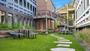 A courtyard with outdoor seating, a stone pathway, and a multi-level structure with a staircase. - 5 minute walk to PCMR! Stylish condo in the heart of town! Hot Tub, EZ Bus. (Park City)