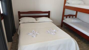 A single bed with white linens and two towels folded on the bed. A bunk bed is visible to the right.