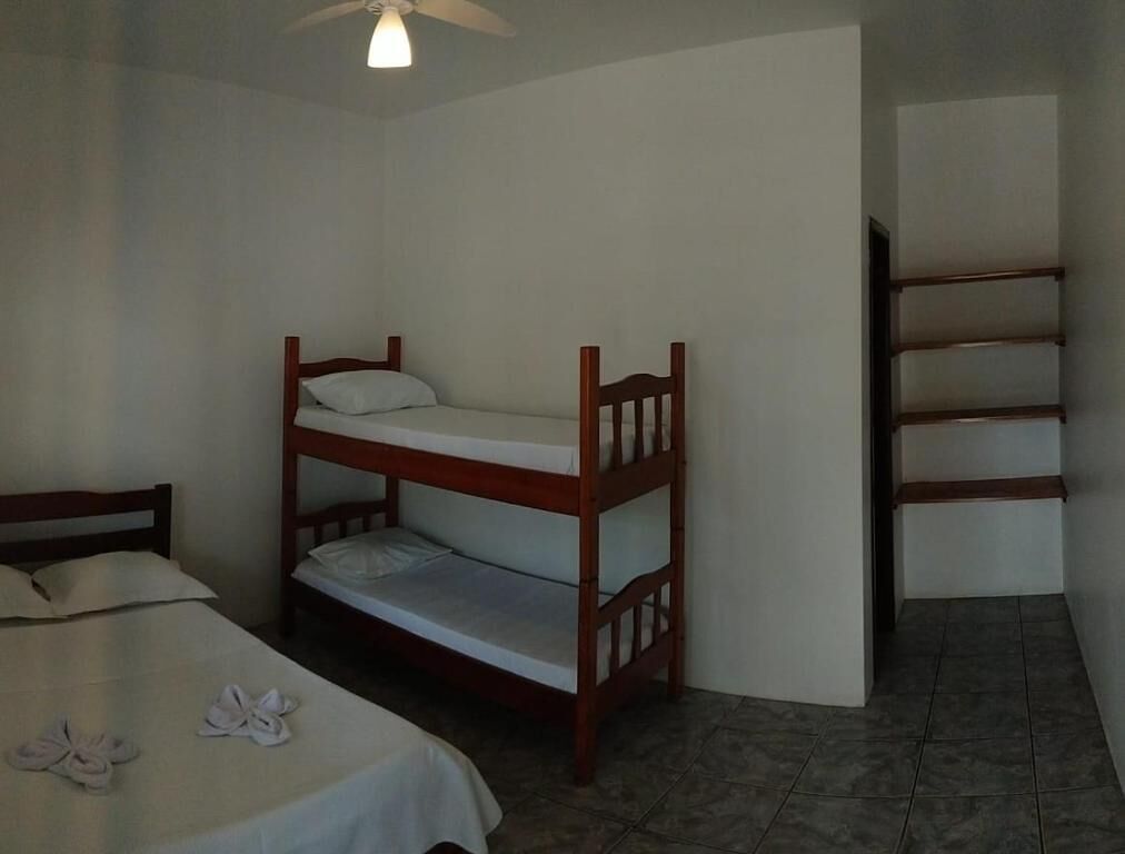 Una habitación con literas, una cama individual y un armario empotrado.