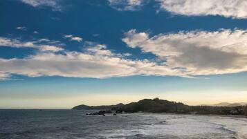 A coastal landscape with a view of the sea and a distant hill.