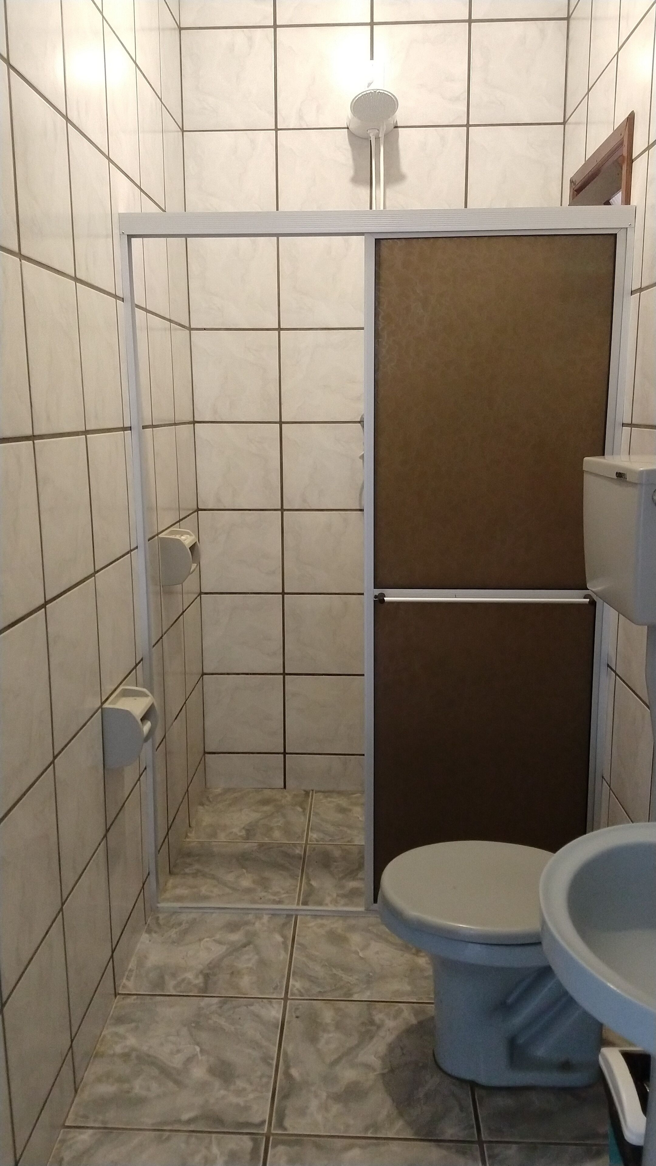 A small bathroom with a toilet, a sink, and a shower stall.