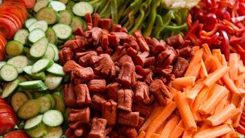 A variety of sliced vegetables including cucumbers, carrots, and tomatoes.
